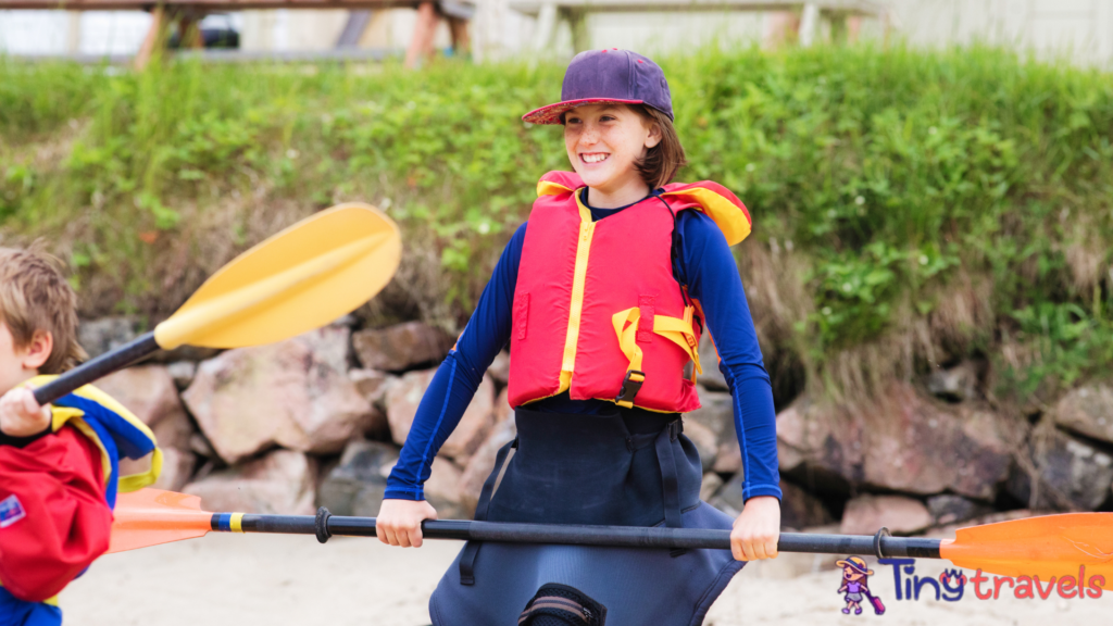 Preteen female in kayaking gear ready to depart⁠