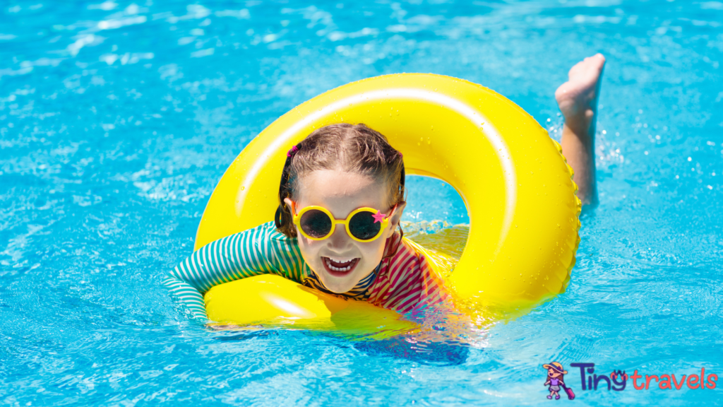 Child in swimming pool on ring toy. Kids swim.⁠
