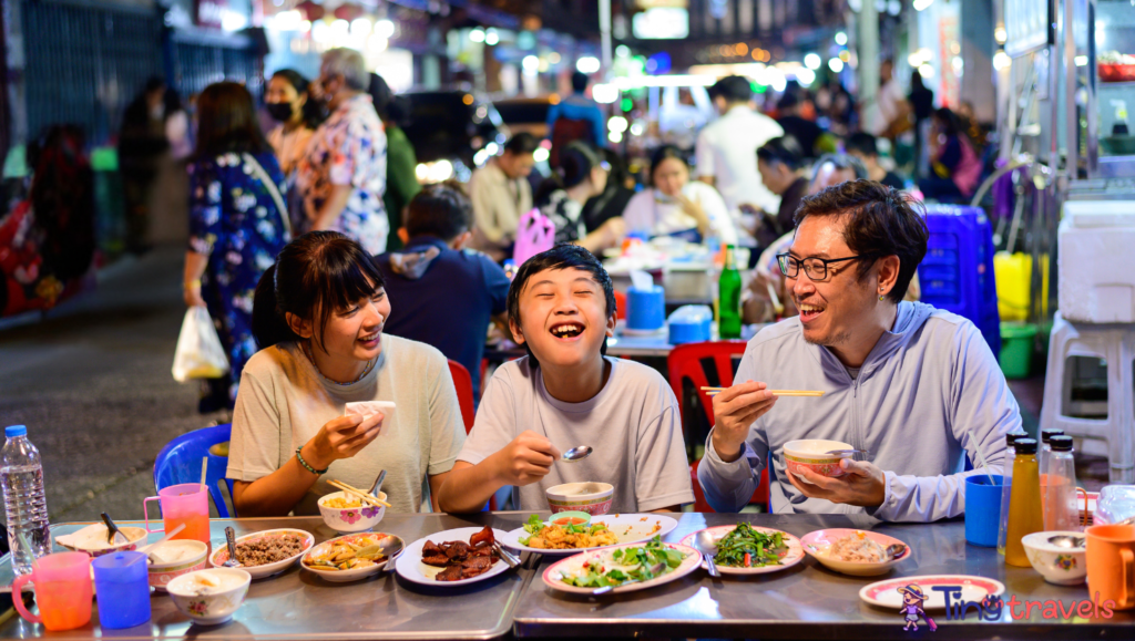 Asian family enjoy eating food on street food restaurant with crowd of people at Yaowarat road, Bangkok⁠