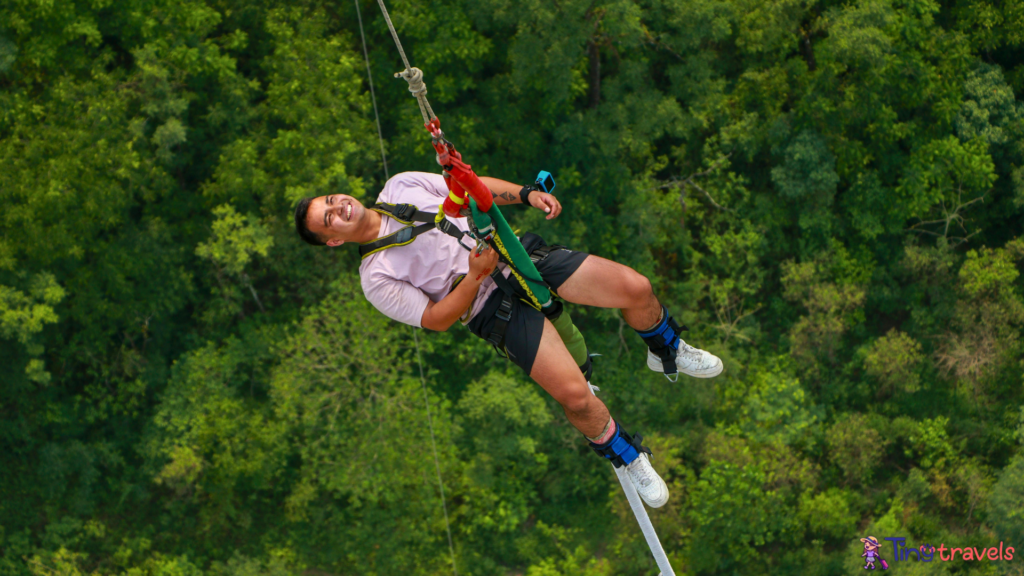 A man is riding a zip line in the air⁠